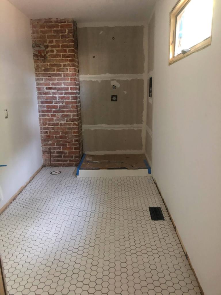 Floor tile laid and grouted. I used 2 inch white hex tile from Floor and Decor and Gray Mapei pre-mixed grout